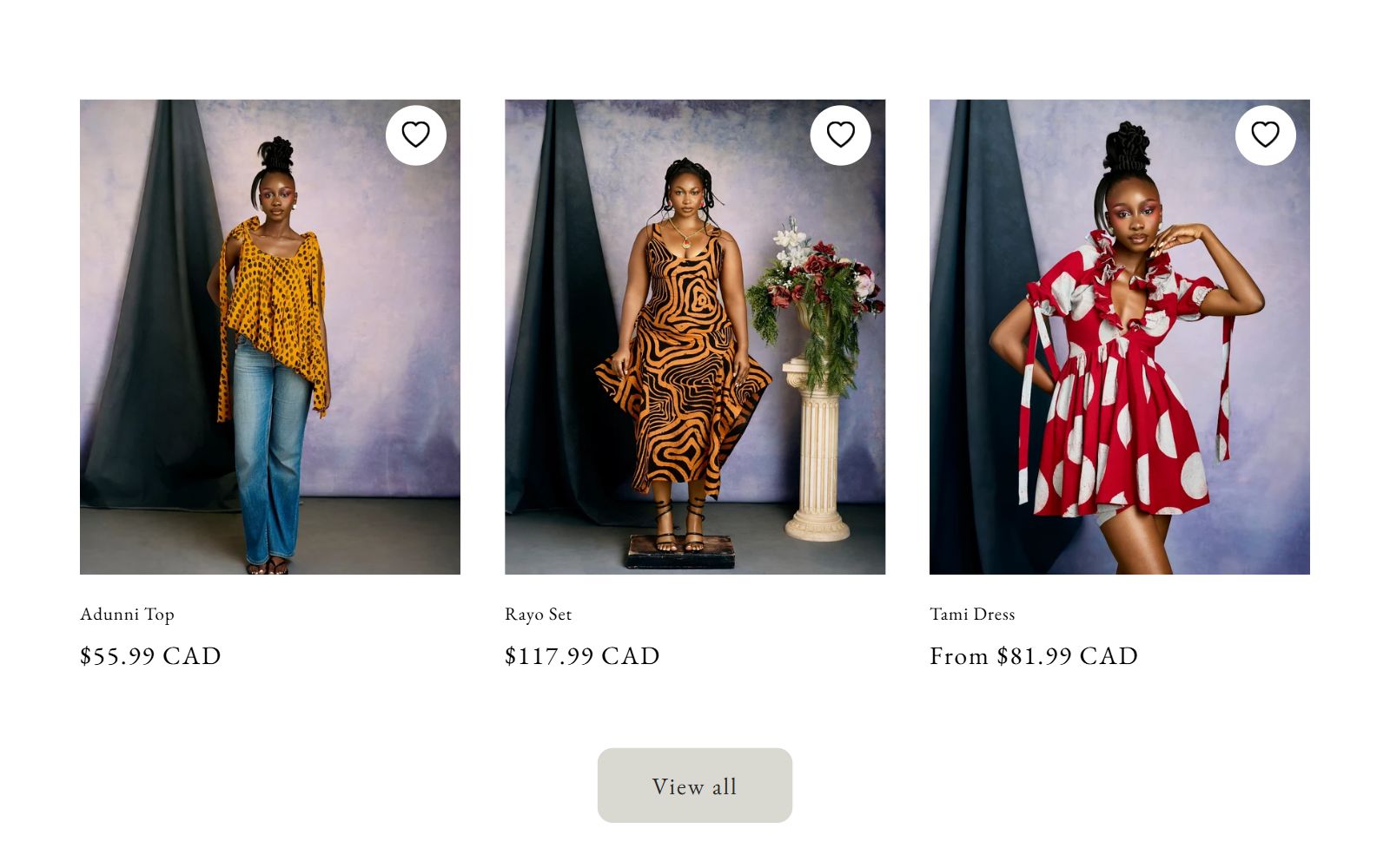 Three KiloKosi lookbook cards on a mottled studio backdrop: the Adunni Top in yellow print with jeans, the orange swirl-print Rayo Set, and the red polka-dot Tami Dress, with names, prices in Canadian dollars, wishlist hearts, and a View all button.